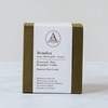 An olive green textured candle box with a letterpressed bellyband