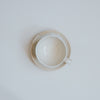 Cream stoneware coffee cup and saucer from above