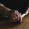 Hands hammering a brass dish